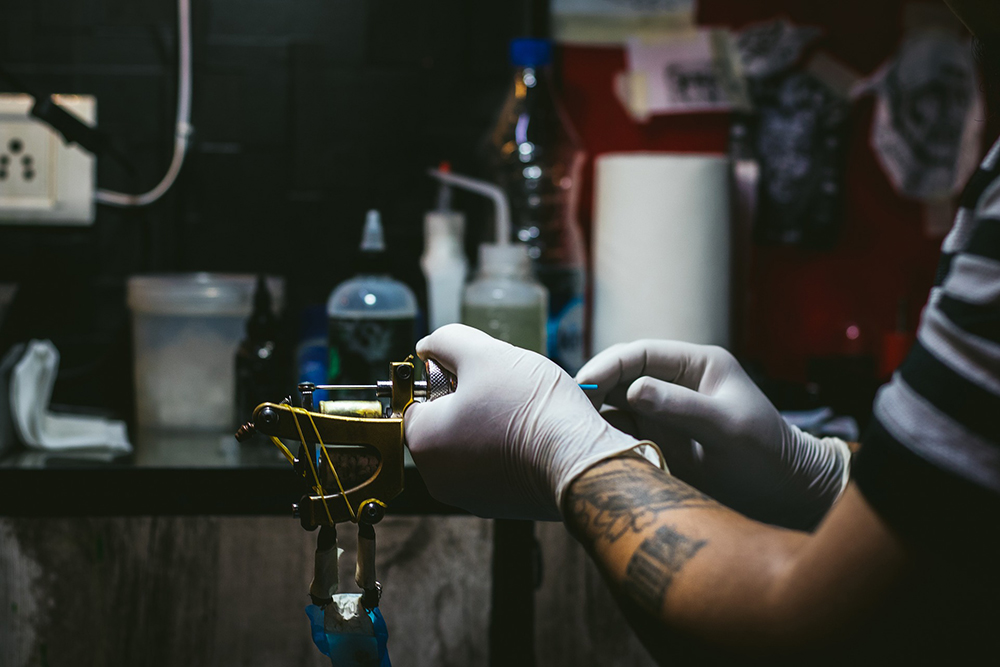 tattoo-artist-safety-equipment tattoo artist wearing personal protective equipment