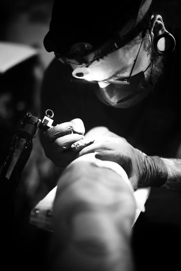 Tattoo artist working in a tattoo shop tattoo artist working in a tattoo shop
