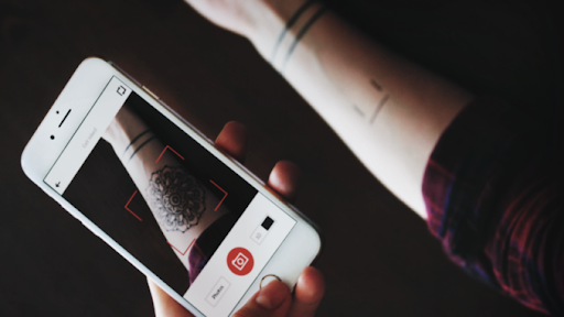 man-holding-a-phone augmented reality image showing tattoo inked onto skin