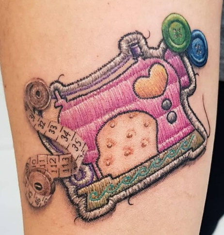 Tattoo of a sewing machine Tattoo of a sewing machine with loose threads to make it look more like embroidered patches