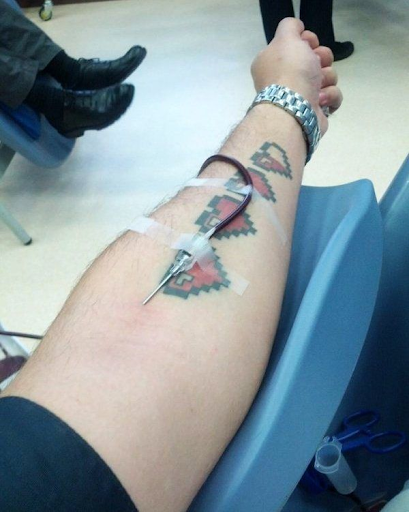 Tattooed Person donating blood Tattooed Person donating blood